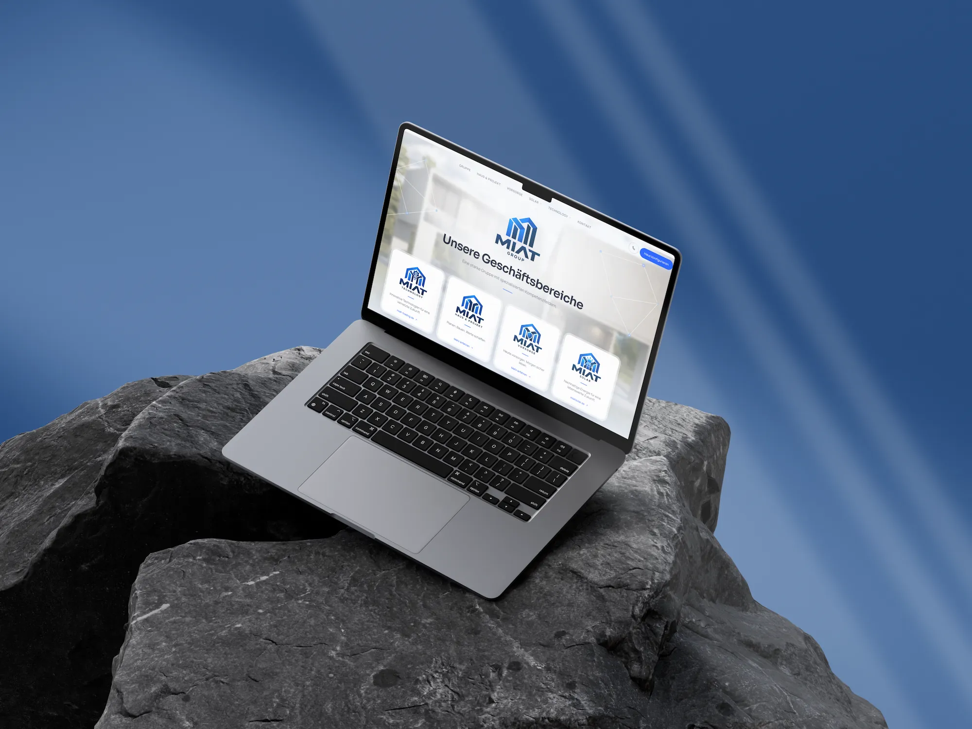 MIAT Group — главная страница «Unsere Geschäftsbereiche» («Наши направления») на MacBook, стоящем на камне
